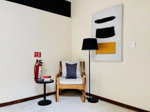 uma sala de estar com uma cadeira e um candeeiro em Unaluna by Rotamundos em Tulum