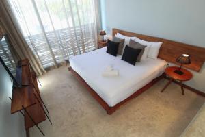 1 dormitorio con cama blanca y ventana grande en Unaluna by Rotamundos en Tulum