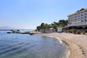 uma praia de areia ao lado de um edifício e da água em Apartments by the sea Trogir - 21588 em Trogir