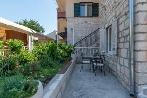 um pátio com uma mesa e cadeiras ao lado de um edifício em Apartments by the sea Trogir - 21588 em Trogir
