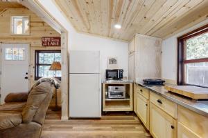 a kitchen with a refrigerator and a couch in a room at Little Pine Cabin at Big Pine Retreat in Crescent