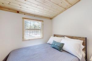 a bedroom with a bed and a window at Little Pine Cabin at Big Pine Retreat in Crescent