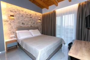 a bedroom with a bed and a large window at Elais Luxury Villas in Parga