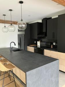 a kitchen with black cabinets and a black counter top at Yin et Yang in Sainte-Anne-de-Beaupré