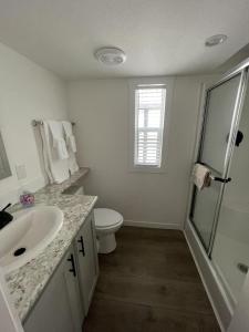 a white bathroom with a sink and a toilet at HTR TX Hill Country Campground in Kerrville