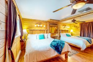 2 camas en una habitación con paredes de madera en Cedaredge Lodge, Cabin 1 en Cedaredge