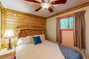 um quarto com uma cama e uma ventoinha de tecto em Cedaredge Lodge, Cabin 5 em Cedaredge