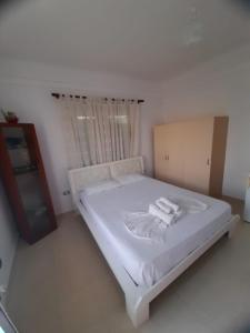 Un dormitorio con una cama blanca con toallas. en Rey Garden 2 en Vlorë