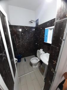 a bathroom with a toilet and a sink at Rey Garden 2 in Vlorë