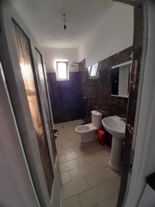 baño con 2 aseos y lavamanos en Rey Garden 2, en Vlorë