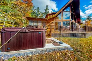 a log cabin with a hot tub in the yard at Autumn Hill Lakehouse in Hinsdale