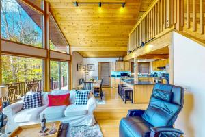 a living room with two couches and a kitchen at Autumn Hill Lakehouse in Hinsdale