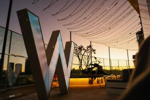 a person sitting on a roof with a view of the city at W Brisbane in Brisbane