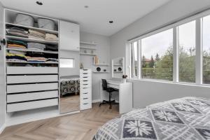 a bedroom with a bed and a desk and a window at A modern and stylish furnished house in Reykjavík in Reykjavík
