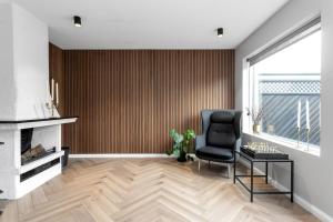 a living room with a chair and a fireplace at A modern and stylish furnished house in Reykjavík in Reykjavík