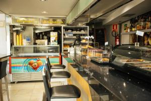 a fast food restaurant with a counter with chairs at Hotel Montedobra in Torrelavega