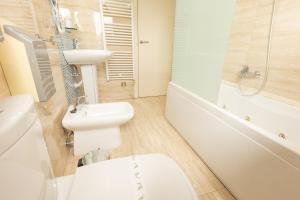 a bathroom with a sink and a toilet and a bath tub at Hotel Montedobra in Torrelavega