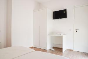 um quarto com paredes brancas e uma televisão na parede em Mega Hotel em Gjirokastër