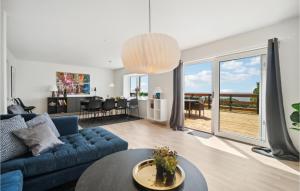 a living room with a blue couch and a table at Gorgeous Home In Hasle With House Sea View in Hasle