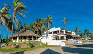 a building on the beach with palm trees at Mar Paraiso Queen in Acapulco