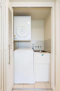 a small kitchen with a white refrigerator and a sink at Resort On The Beach 5118 with resort Pool in Kingscliff