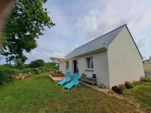 a house with two chairs and a table and an umbrella at Single storey holiday home in Plouarzel in Plouarzel