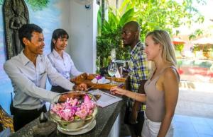 un gruppo di persone che si trovano intorno a un tavolo con una ciotola di cibo di ERCAN BOUTiQUE a Siem Reap