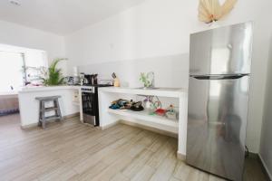 uma cozinha com frigorífico e piso em madeira em Casa Fenix em Sayulita