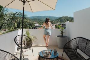 a woman standing on the ledge of a balcony at Casa Fenix in Sayulita