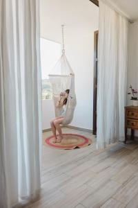 a woman sitting in a hammock in a room at Casa Fenix in Sayulita
