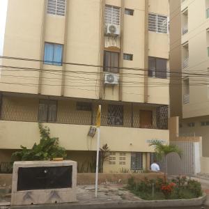 un edificio de apartamentos con una bandera delante de él en Habitación en apartamento compartido al frente del cc Unico, en Barranquilla