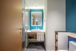 a bathroom with a sink and a mirror at Holiday Inn Express Jurong Xianlin in Zhenjiang