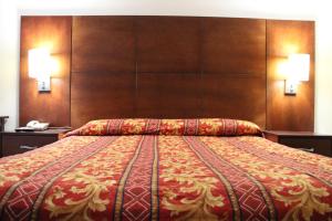 a large bed in a hotel room with two lamps at Flagstaff Motel in Flagstaff