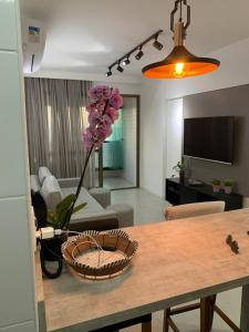 ein Wohnzimmer mit einem Tisch mit einer Blume in einem Korb in der Unterkunft Barra 535 Vista Mar in Salvador + 35 Fotos
