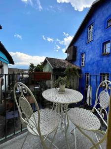 a table and chairs on a balcony with a blue building at LA GIALLA di Via Silvano 12 in Monforte dʼAlba
