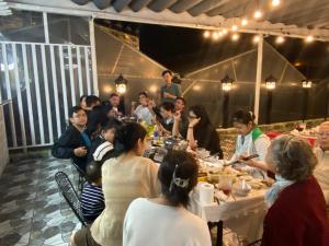 un grupo de personas sentadas en una mesa comiendo en villa Trung Nghĩa 5, en Da Lat