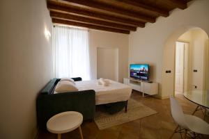 een slaapkamer met een bed en een televisie en een tafel bij Dolce Vita Apartment - Salò in Salò