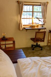 um quarto com uma cama, uma secretária e uma janela em 彎腰拾光旅人空間Good Old Times em Chenggong