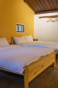 um quarto com uma cama grande e lençóis brancos em 彎腰拾光旅人空間Good Old Times em Chenggong