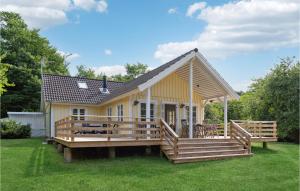 HøjbyにあるNice Home In Hjby With 3 Bedrooms And Wifiの小さな黄色の家(大きなデッキ付)