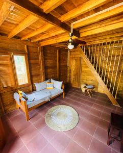 - un salon avec un canapé dans une maison en bois dans l'établissement SAJA Cottage, Gili Meno, à Gili Meno
