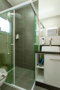 a bathroom with a glass shower with a sink at La Casita Bem Gaúcha in Porto Alegre