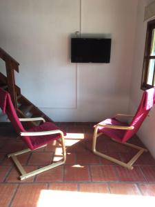 Duas cadeiras num quarto com uma televisão de ecrã plano em Cabanas Cucu em Piriápolis