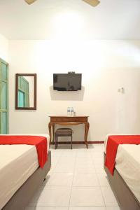 una camera d'albergo con due letti e un pianoforte di RedDoorz near Pojok Beteng Prawirotaman a Yogyakarta