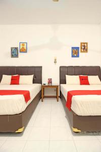 2 Betten nebeneinander in einem Zimmer in der Unterkunft RedDoorz near Pojok Beteng Prawirotaman in Yogyakarta