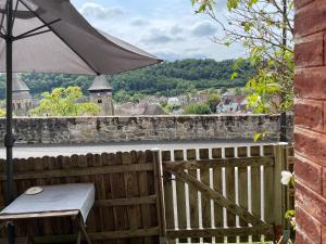 a table and an umbrella on a wooden fence at La Symbiose 23 in Chambon-sur-Voueize