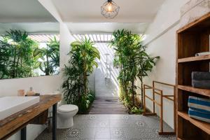 a bathroom with potted plants in the hallway at Secret Haven Cozy 3 Bedroom Private Pool Villa in Gili Trawangan