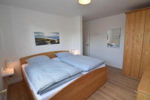 ein Schlafzimmer mit einem Bett mit blauen Kissen darauf in der Unterkunft fewo1846 - Nordlicht - zentral gelegene Wohnung im EG mit Wintergarten und Terrasse in Harrislee