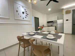 クアラルンプールにある10Pax 4 Room Hidden Gem Sri Petaling 3 min Bukit Jalil Stadiumのキッチン(テーブル、椅子、壁掛け時計付)