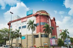 クアラルンプールにある10Pax 4 Room Hidden Gem Sri Petaling 3 min Bukit Jalil Stadiumのヤシの木が前に生えている大きな建物